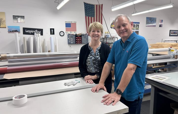 Woman and man stand in framing shop.